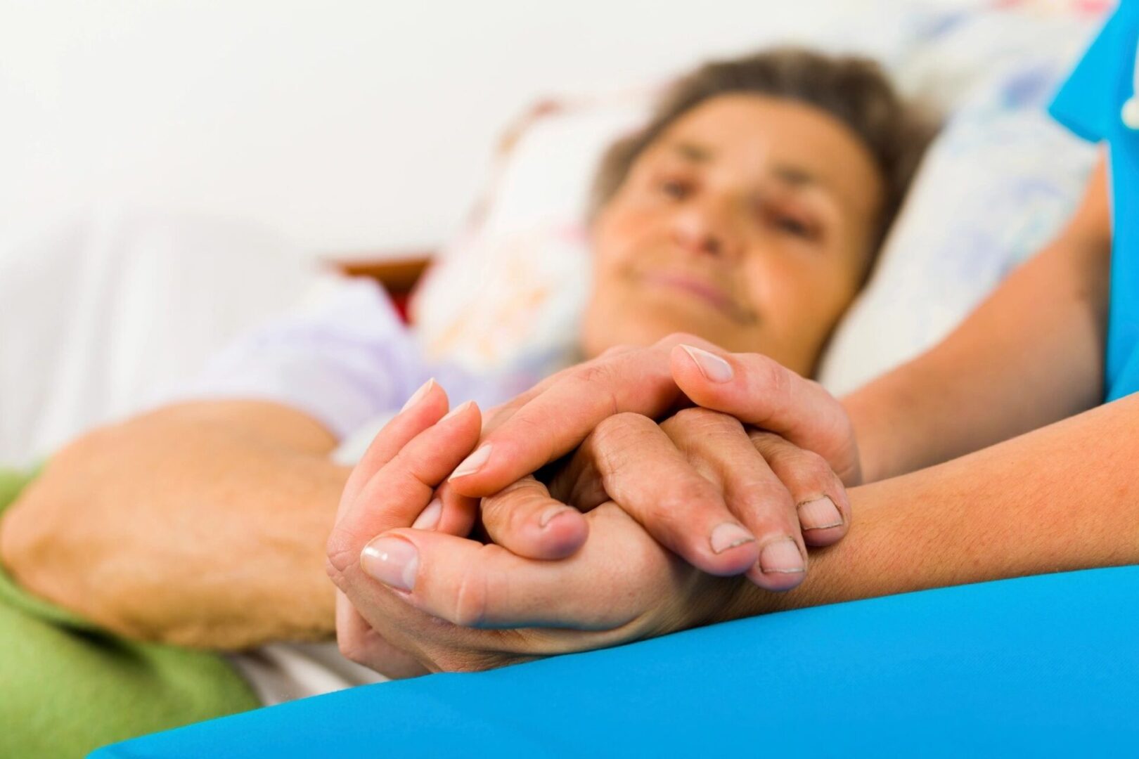 Nurse Holding Elderly Patient's Hand